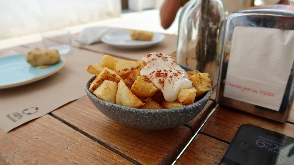 top 10 tapas dishes featuring grilled vegetables, olives, marinated anchovies, and lentil salad on rustic wooden table near Bernabéu stadium